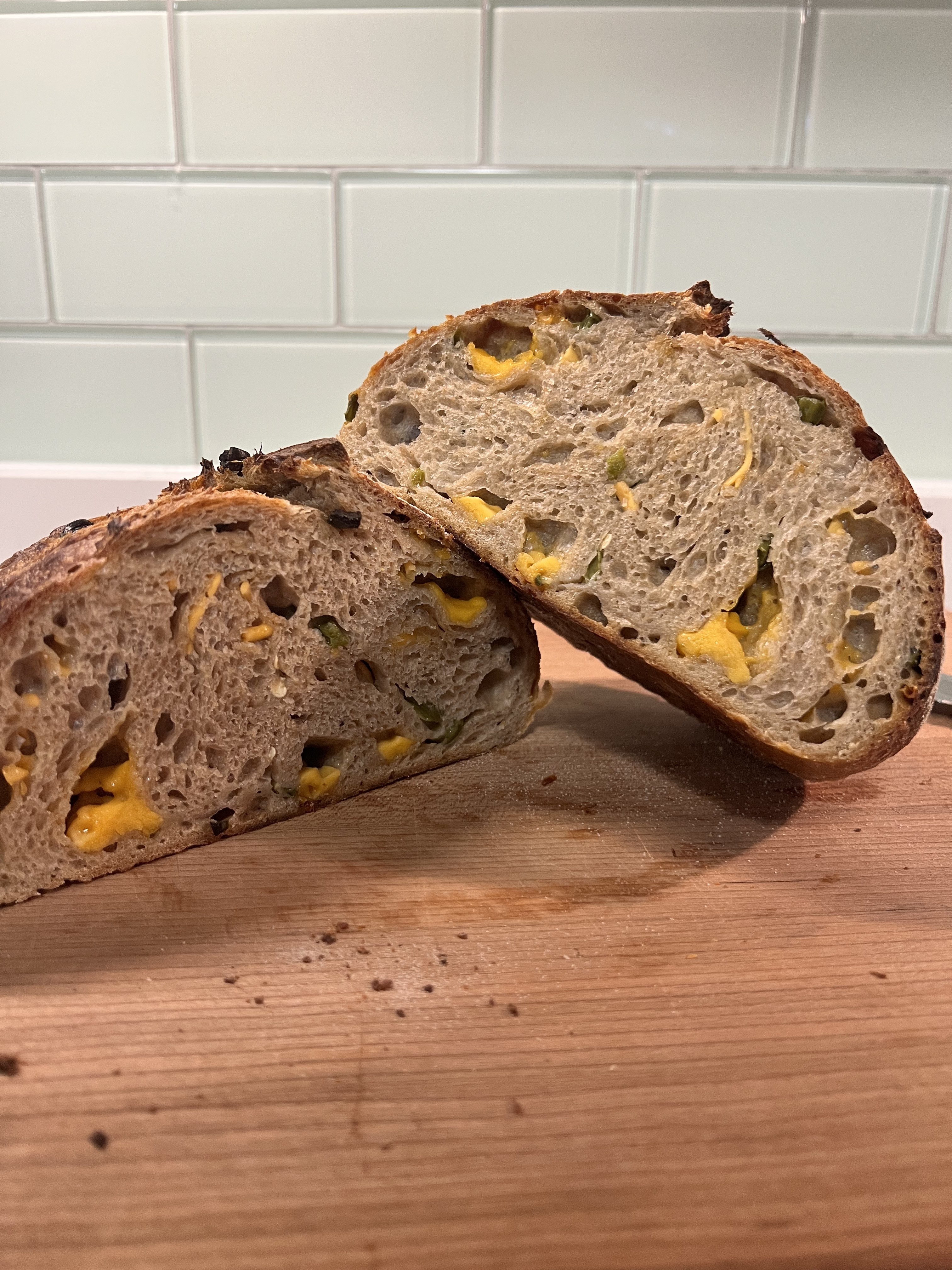Cheddar jalapeño sourdough sliced open — melted cheddar and jalapeño throughout the crumb